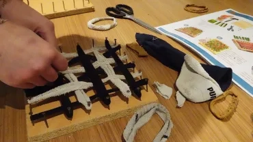 Gros plan sur les mains d'une adulte qui fabrique une éponge tawashi