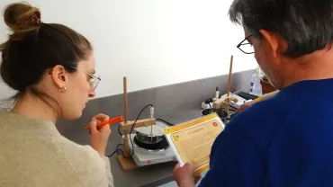 Deux adultes font une expérience avec des casseroles d'eau chaude