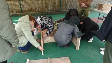 5 adultes rassemblent les différentes parties de la jardinière 