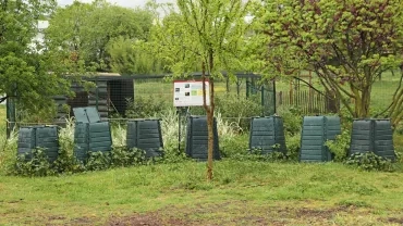 7 composteurs de jardin sur une surface enherbée