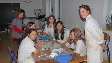 Un groupe d'enfants et leur animatrice sont en train de peindre