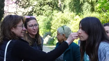 Une adulte fais sentir l'odeur des plantes sur ses doigts à une autre adulte