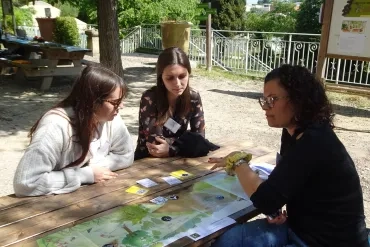 une animatrice présente un outil pédagogique à une adulte