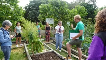 un animateur montre différentes techniques de paillage à un groupe d'adultes