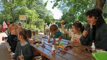 un groupe d'enfants et leur animatrice montrent des étoiles décorées