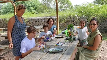 des parents et leurs enfants collent des éléments naturels