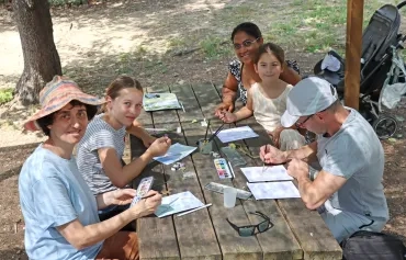 des parents et leurs enfants dessinent sur des tables