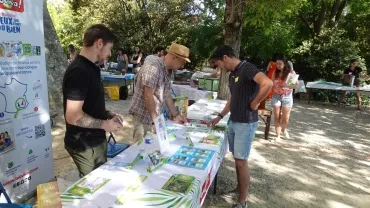 deux animateurs de Bioviva présentent leurs jeux à un adulte