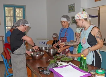 un groupe d'enfants et leur animatrice font de la cuisine 
