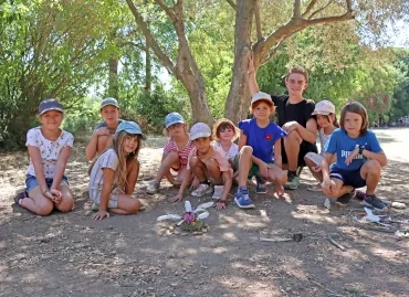 Un groupe d'enfants et leur animateur posent devant leurs créations en éléments naturels