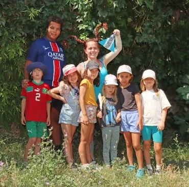 un groupe d'enfants et leur animatrice déguisée en extraterrestre posent avec une petite fusée 