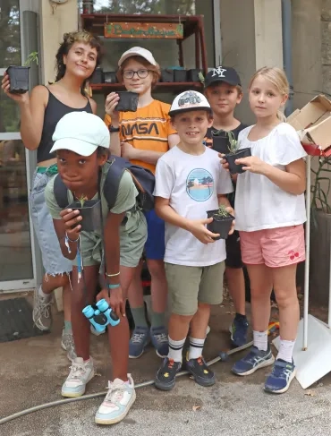 Un groupe d'enfants et leur animatrice posent avec leur bouture