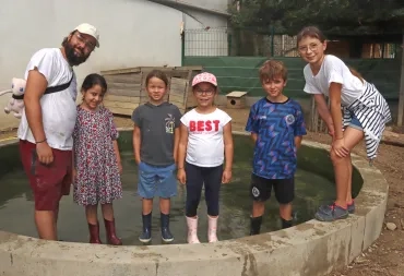 Un groupe d'enfants et leur animateur sont dans un bassin