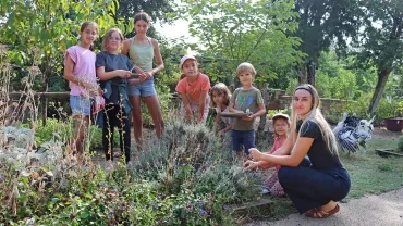 Un groupe d'enfants et une animatrice cueillent de la lavende
