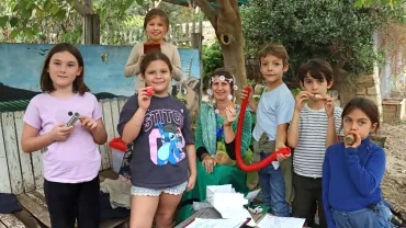 un groupe d'enfants et leur animatrice montrent des instruments de musique