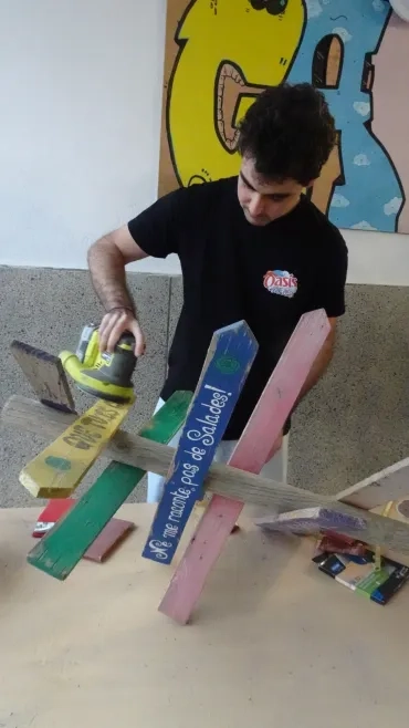 Un participant ponce un panneau de bois 