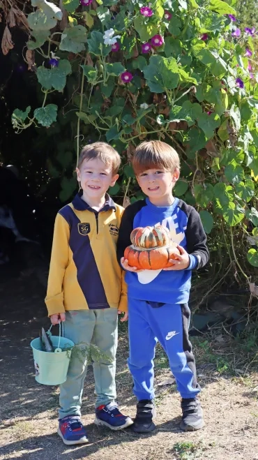 deux enfants posent avec une courge
