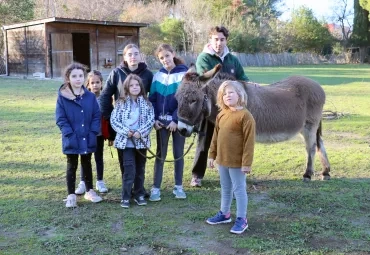 un groupe d'enfants et leur animateur posent avec un âne