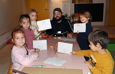 un groupe d'enfants et leur animateur montrent cartons avec une pique au centre