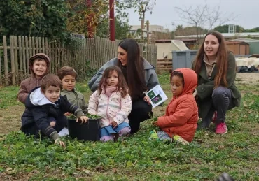 un groupe d'enfants et leurs animatrices ramassent de l'herbe
