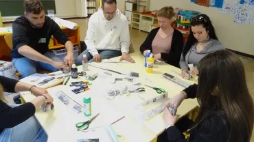 Les participants réalisent des pots en papier journal.