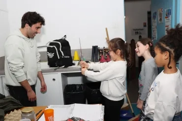 un groupe d'enfants et leur animateur manipulent un thermomètre