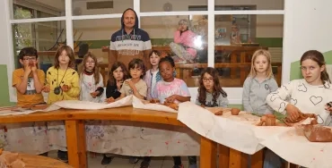 Un groupe d'enfants et leur animateur montrent leur réalisations