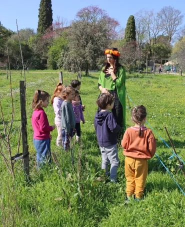 Un groupe d'enfants et leur animatrice déguisée se balade dans le parc