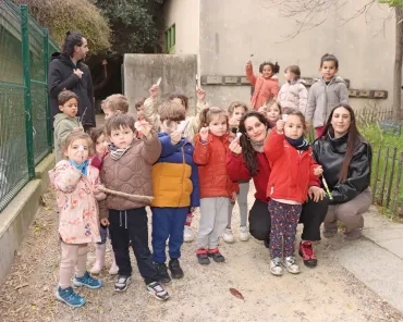 Un groupe d'enfants et leurs animateurs posent avec des plumes dans les mains