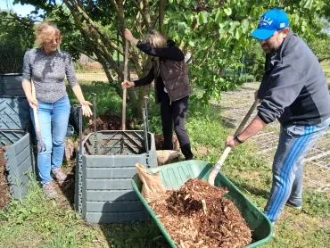 Un participant rajoute dans le compost du broyat, de la matière sèche.
