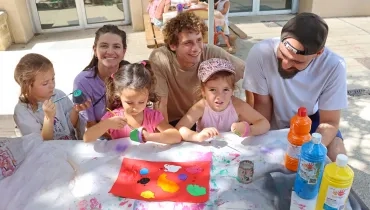 un groupe d'enfants et leurs animateurs peignent des pots en terre