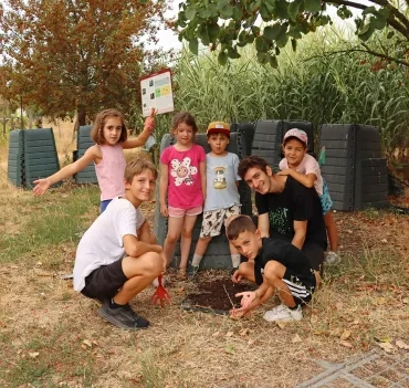 un groupe d'enfants et leur animateur cherche dans un tas de terre