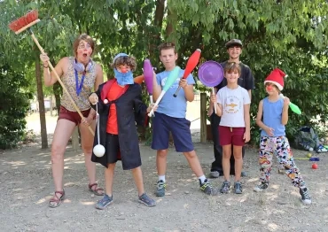 un groupe d'enfants et leur animatrice sont déguisés avec des accessoires colorés
