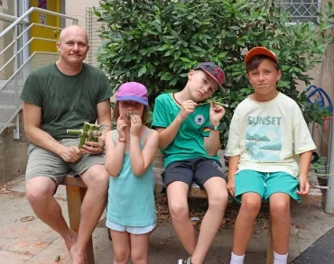 un groupe d'enfants et leur animateur posent avec des morceaux de bambous