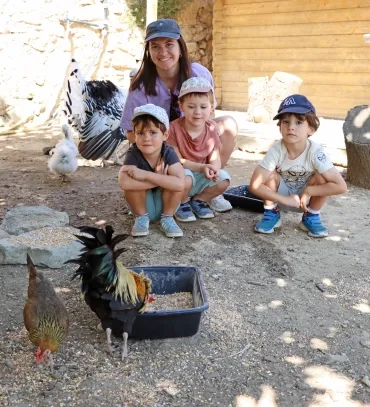 Un groupe d'enfants et leur animatrice posent avec des volailles