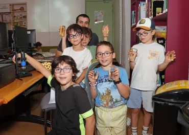 Un groupe d'enfants et leur animateur montrent des insectes dans de la résine