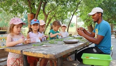 Un groupe d'enfants et leur animateur mettent des plantes en sachet