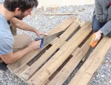 Deux adultes scient une palette