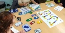 Un jeu de plateau sur une table, présenté par une animatrice