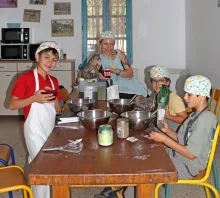 Un groupe d'enfants et leur animatrice montrent des ingrédients en cuisine