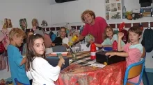 Un groupe d'enfants et leur animateur peignent des boites à chaussures