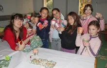 un groupe d'enfants et leur animatrice montrent des pots en terre décorés