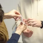 Un animateur aide un participant à effectuer un noeud de huit doublé