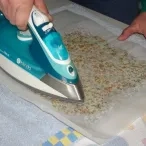 un adulte utilise un fer à repasser sur un bee wrap