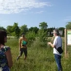 Un animateur présente à un groupe d'adultes un aménagement naturel devant un tableau de présentation 
