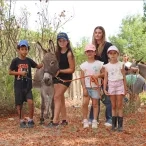 Un groupe d'enfants et leur animatrice posent avec un âne