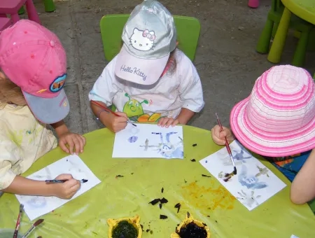 Trois enfants font de la peinture avec des colorants naturels